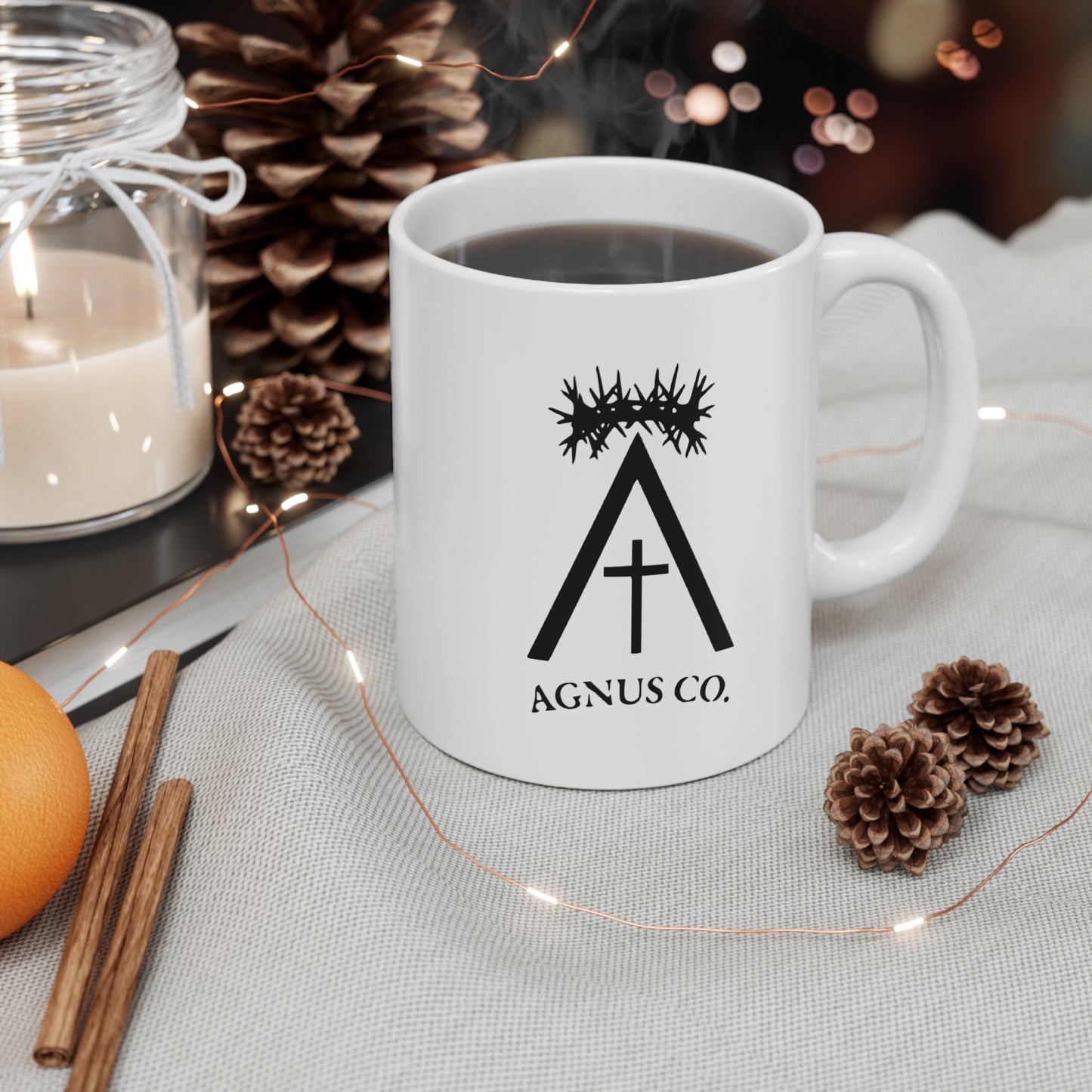 Agnus Co. Catholic coffee mug — lifestyle shot with coffee and seasonal decor