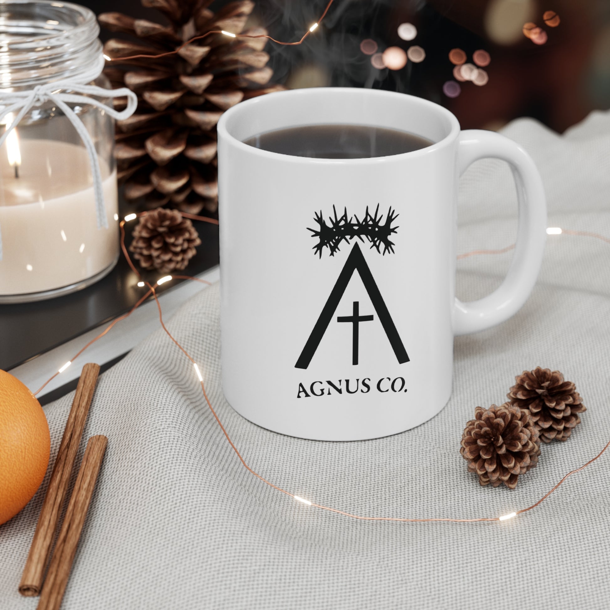 Agnus Co. Catholic coffee mug — lifestyle shot with coffee and seasonal decor